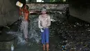 Dua laki-laki mandi di bawah sebuah jembatan di daerah kumuh di Kalkuta, India (26/5/2016). Kalkuta adalah salah satu kota pelabuhan penting di India yang merupakan ibu kota Benggala Barat. (REUTERS/Rupak De Chowdhuri)