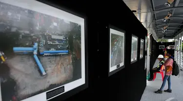 Pengunjung mengamati pameran foto jurnalis 'Satu Tahun Groundbreaking MRT di JPO Bundaran HI, Jakarta, Jumat (31/10/14). (Liputan6.com/Johan Tallo)