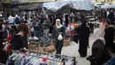 Warga Palestina yang mengungsi berbelanja di kios-kios pasar jalanan sekitar kamp pengungsi Nuseirat, Jalur Gaza tengah, pada Rabu 18 Maret 2026. Meski berada dalam situasi sulit dan di tengah reruntuhan, pasar jalanan sekitar kamp pengungsi Nuseirat, Jalur Gaza tengah, tetap ramai dikunjungi warga Palestina yang mengungsi. (Eyad Baba/AFP)