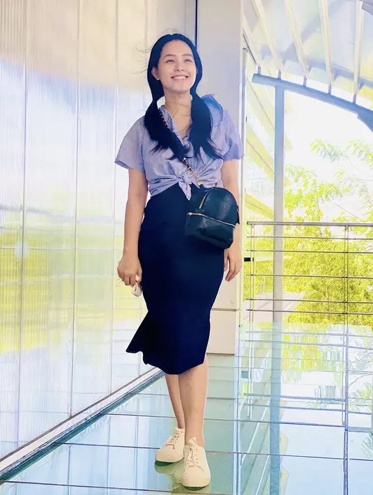 .Ia juga tampil dengan atasan kemeja dipadukan skirt hitam membawa sling bag hitamnya. Cantiknya pun effortless (@ladykjaernett)