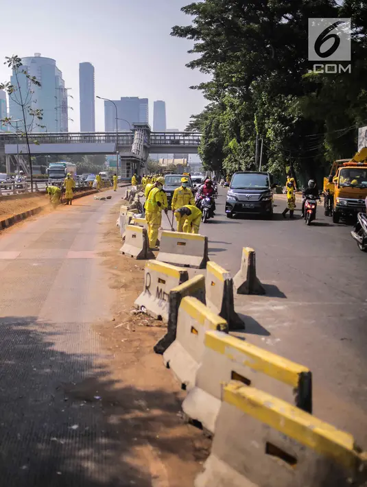 Petugas Dinas Bina Marga DKI Jakarta memperbaiki separator busway di kawasan Jalan Gatot Subroto, Jakarta, Selasa (1/10/2019). Separator busway dirusak massa saat terjadi bentrok antara polisi dengan demonstran di kawasan tersebut. (Liputan6.com/Faizal Fanani)