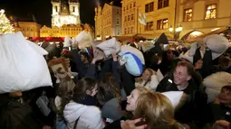 Sejumlah warga saat megambil bagian dalam flash mob perang bantal selama empat menit di Old Town Square di Praha,Ceko (22/12). flash mob perang bantal ini dilakukan jelang pergantian akhir tahun. (REUTERS/ David W Cerny)