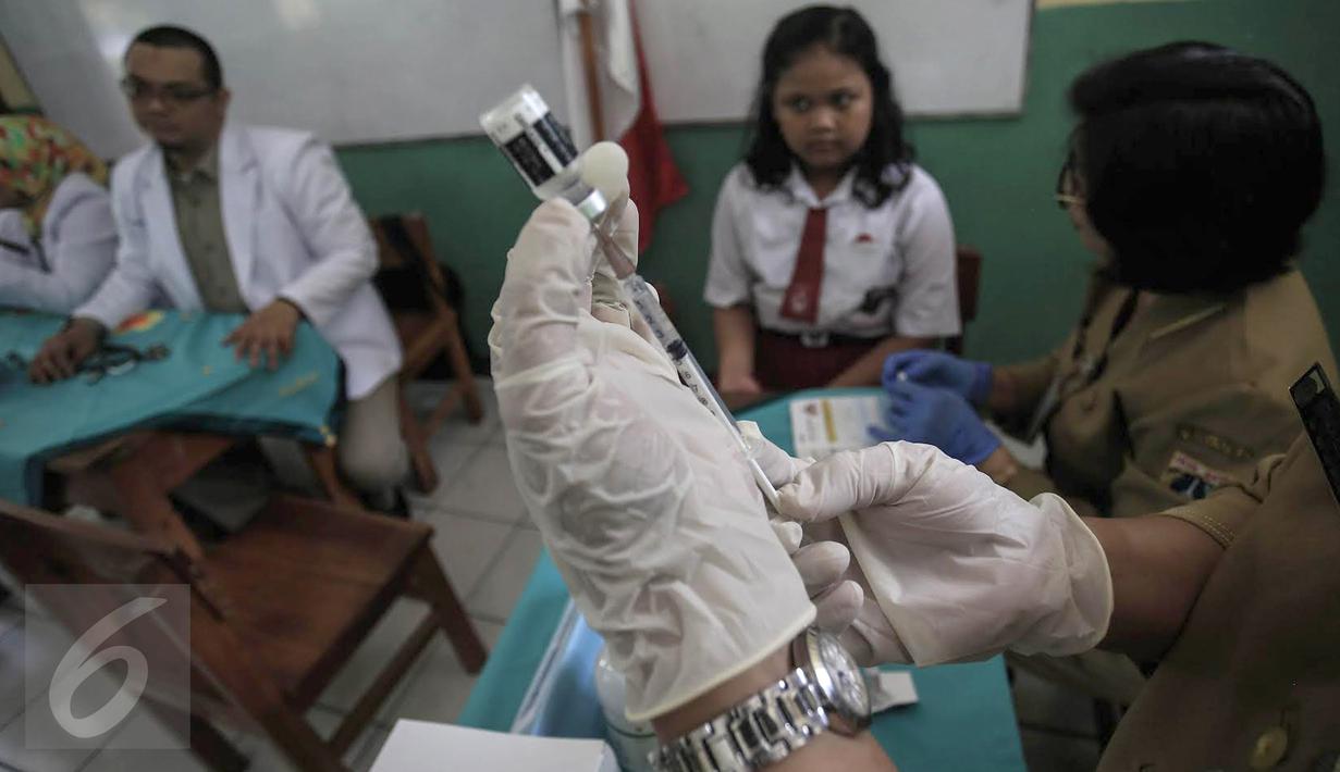 Dokter bersiap memberikan suntikan imunisasi di SDN 11 Pagi, Lubang Buaya, Jakarta, Selasa (4/10). Kegiatan ini untuk mewujudkan Indonesia bebas dari kanker serviks. (Liputan6.com/Faizal Fanani)
