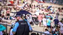 Seorang polisi berpatroli saat orang-orang mengunjungi pantai Bondi di Sydney, Australia pada 5 Oktober 2020. Pengunjung ramai berjemur dan bermain di pantai dan berenang di laut saat pandemi Covid-19 masih berlangsung.  (Photo by DAVID GRAY / AFP)
