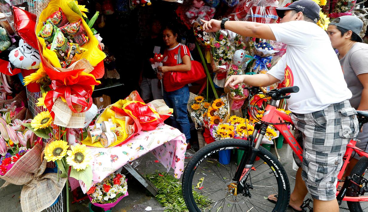 Seorang pembeli melihat bunga yang dijajakan di sebuah pasar bunga sehari sebelum Valentine Day di Manila, Filipina, Rabu (13/2). Sudah tradisi di seluruh dunia, setiap hari valentine identik dengan pemberian bunga atau coklat. (AP Photo/Bullit Marquez)