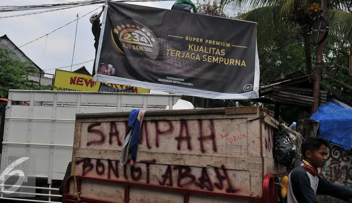 Warga dan petugas Satpol PP menurunkan papan reklame rokok, Jakarta, Rabu (18/11). Gubernur DKI Jakarta menerbitkan Peraturan Gubernur Nomor 1 Tahun 2015 tentang Larangan Penyelenggaraan Reklame Rokok pada Media Luar Ruang. (Liputan6.com/Gempur M Surya)
