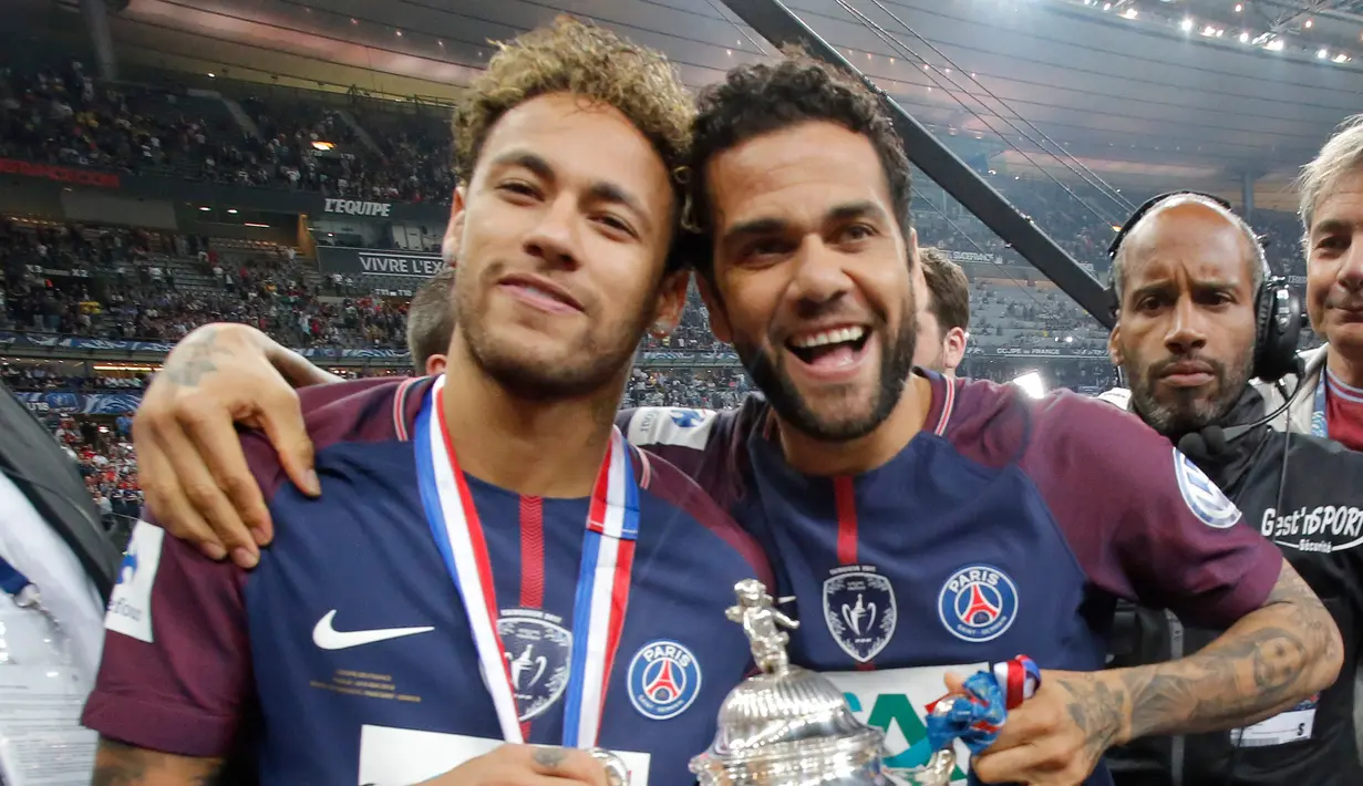Penyerang PSG, Neymar Jr dan Dani Alves tersenyum sambil membawa Piala Prancis di Saint-Denis, Paris (8/5). Meski dalam kondisi cedera, Neymar tetap hadir menyaksikan timnya bertanding di final melawan Les Herbiers.  (AFP Photo/Franck Fife)