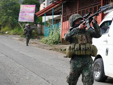 Tentara Filipina mengarahkan senjatanya saat bertempur melawan militan maute di kota Marawi, (28/5). Pasukan Filipina melancarkan serangan udara pada hari Minggu untuk mengusir militan yang terkait dengan kelompok ISIS. (AP Photo/Bullit Marquez)