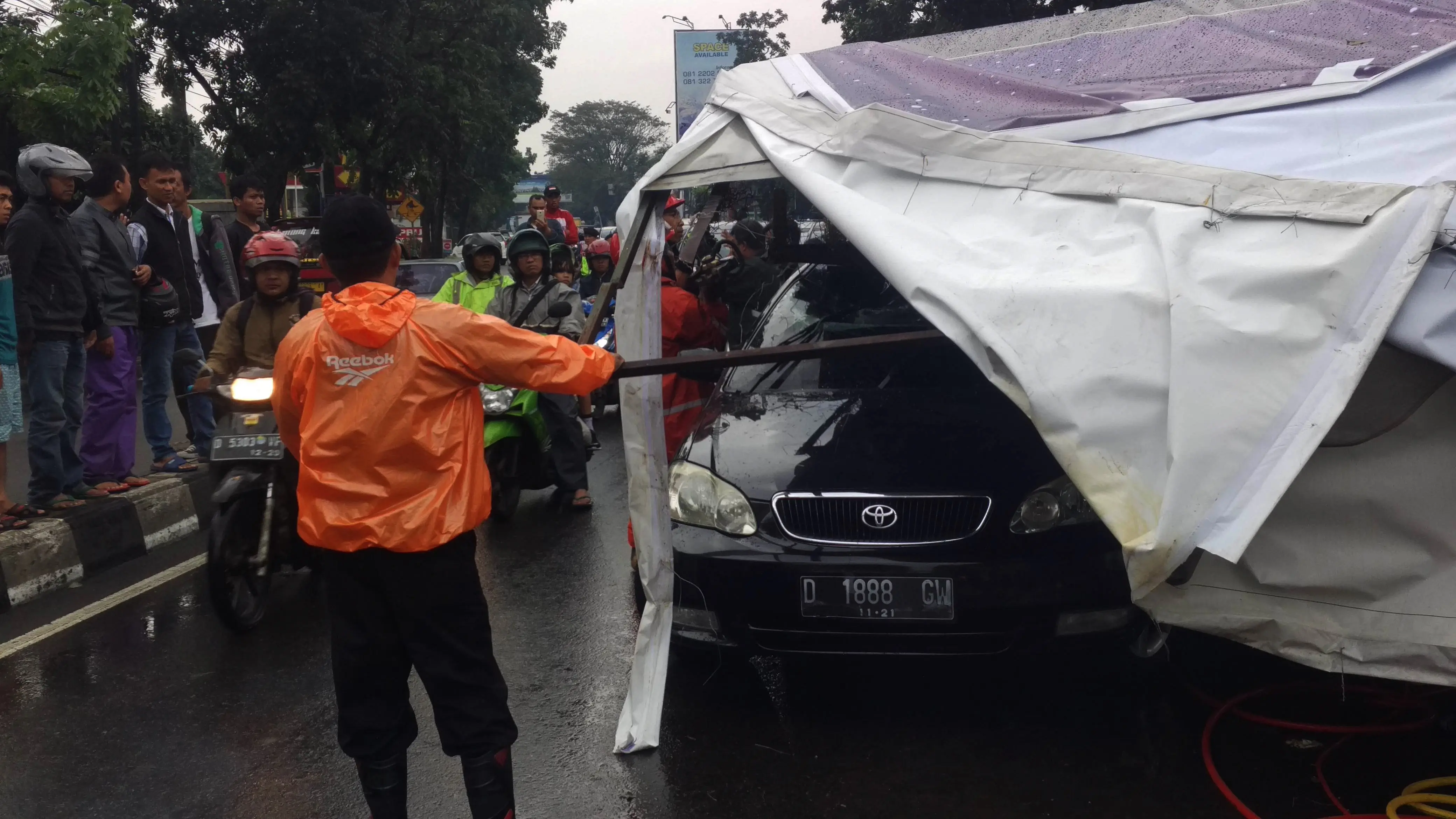 Sebuah sedan tertimpa baliho roboh akibat hujan es dan angin kencang yang menerjang Kota Bandung, Jabar. (Liputan6.com/Kukuh Saokani)