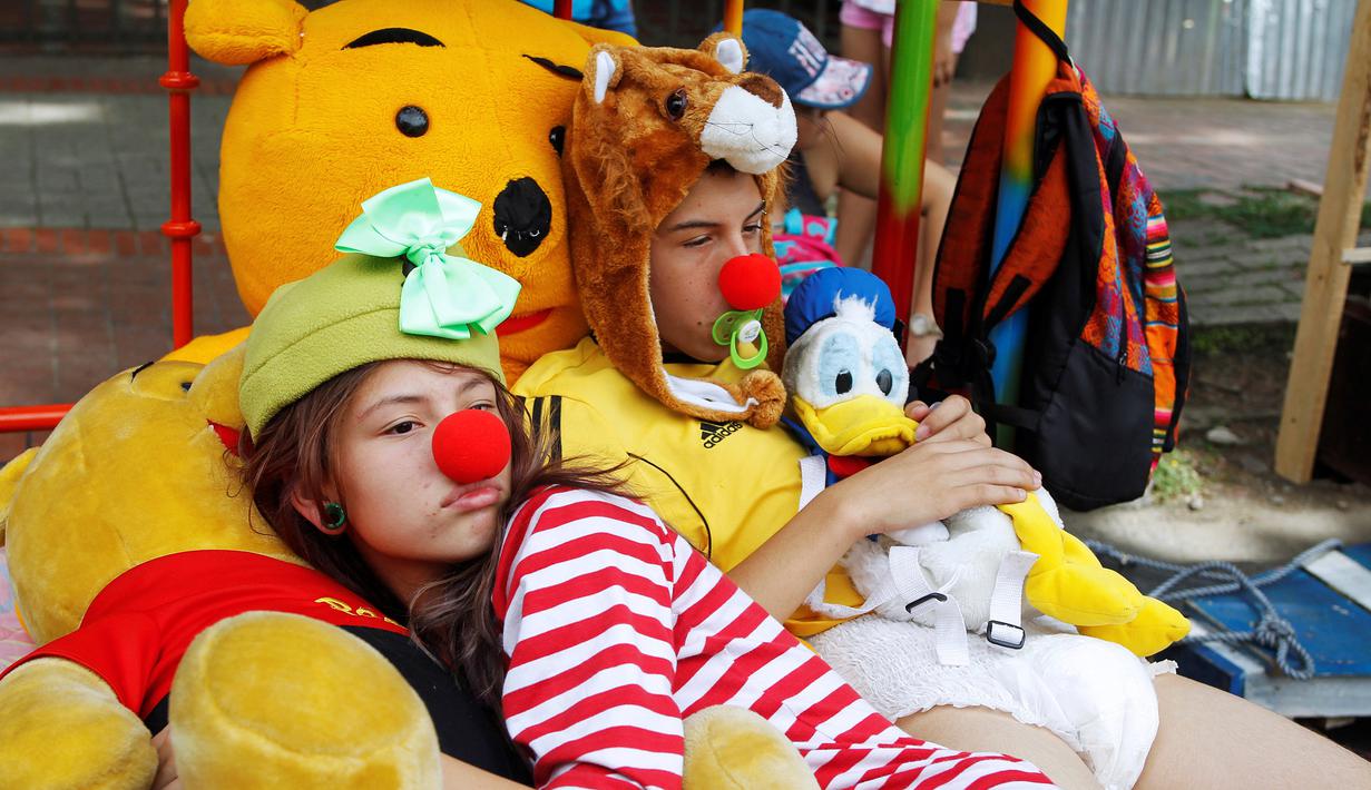  Dua peserta memakai piyama memeluk boneka saat tidur bersama di atas ranjang saat acara Hari Malas Sedunia di Ibague, Kolombia, (14/8). Sejumlah orang turun ke jalan membawa tempat tidur dan maainanya untuk bermalas-malasan. (REUTERS/Fredy Builes)