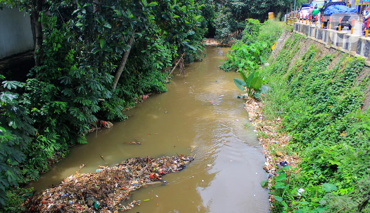 Pemandangan sampah yang memenuhi Kali Baru di Jalan Pitara Raya, Depok, Jawa Barat, Rabu (19/2/2020). Pascahujan deras yang terjadi sehari sebelumnya, sampah dari arah Bogor terbawa aliran Kali Baru hingga ke Depok. (merdeka.com/Magang/Muhammad Fayyadh)