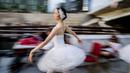 Seorang penari dari Berlin State Ballet menari "Swan Lake" di atas kapal pesiar selama tur pusat kota di Berlin, Jerman, Kamis (10/6/2021). Pertunjukan itu diikuti oleh banyak orang di sepanjang rute. (Christoph Soeder/dpa via AP)