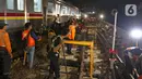 Sejumlah petugas merevitalisasi wesel rel di Stasiun KA Gambir, Jakarta, Kamis (14/2/2020) malam. PT KCI dan PT KAI Daop 1 Jakarta mengganti wesel rel di Stasiun Gambir dan Stasiun Jakarta Kota secara paralel yang akan berlangsung pada 13-23 Februari 2020. (Liputan6.com/Herman Zakharia)