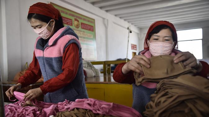 Pekerja Pabrik Pakaian Rajut Songyo membuat masker untuk perlindungan terhadap coronavirus baru di Pyongyang (6/2/2020). Wabah yang dimulai dari kota Wuhan di China tersebut telah menyebar ke puluhan negara di dunia. (AFP/Kim Won-Jin)