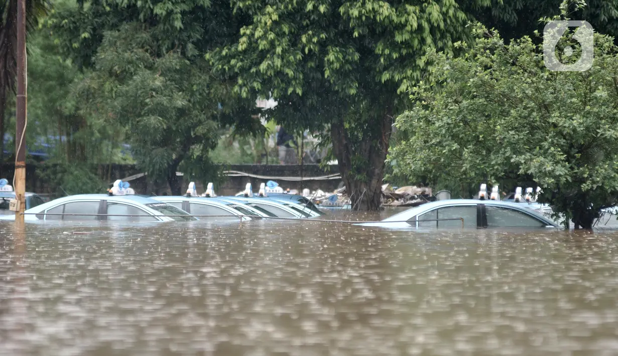 Kondisi taksi saat terendam banjir di Pool Blue Bird, Kramat Jati, Jakarta Timur, Rabu (1/1/2020). Banjir yang terjadi akibat hujan deras yang mengguyur Jakarta dan sekitarnya menyebabkan puluhan taksi dan belasan mobil terendam sejak pukul 04.00 WIB. (merdeka.com/Iqbal S. Nugroho)