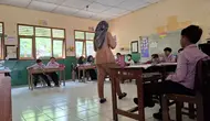 Seorang guru sedang membimbing siswa di dalam kelas. Meski proses belajar mengajar berjalan aktif, sebanyak 20 SMP swasta tidak mendapatkan siswa baru dalam penerimaan murid tahun ajaran 2025/2026.