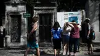 Turis melihat peta pemakaman Pere Lachaise sebelum memulai kunjungan mereka di Paris (22/7/2019). Pemakaman Père adalah salah satu pemakaman terbesar di Paris (luasnya sekitar 44 hektar 110 acre). (AFP Photo/Philippe Lopez)