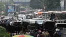Pengunjung berjalan di antara kendaraan yang terjebak kemacetan di Pasar Tanah Abang, Jakarta, Minggu (10/6). H-5 Lebaran, pasar Tanah Abang semakin dipadati pengunjung sehingga lalu lintas kawasan itu semakin parah. (Merdeka.com/Iqbal S. Nugroho)