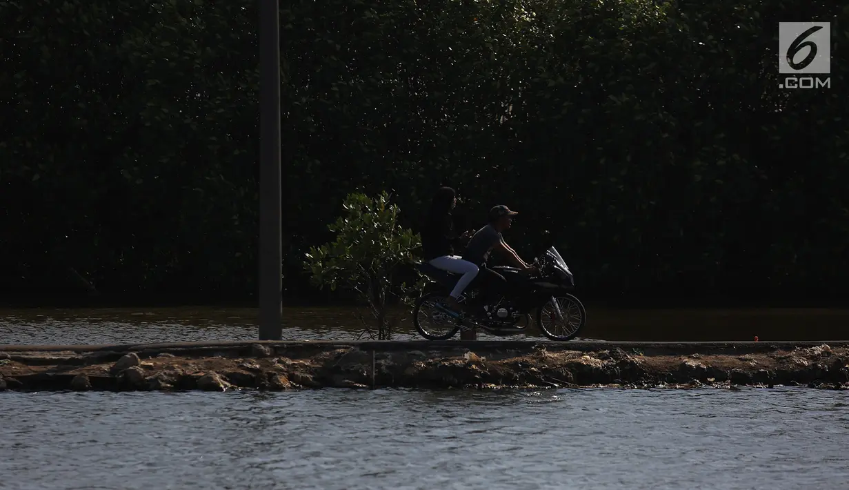 Warga menggunakan sepeda motor menikmati jalan-jalan sore di Pantai Marunda, Teluk Jakarta, Selasa (11/9). Pantai Marunda menjadi tempat alternatif berlibur keluarga dan menghibur diri dengan memancing di bibir pantai tersebut. (Merdeka.com/Imam Buhori)