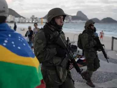Tentara patroli di pantai Copacabana di Rio de Janeiro, Brasil, (30/7). Ribuan tentara mulai berpatroli di Rio de Janeiro di tengah lonjakan kekerasan di kota terbesar kedua di Brasil. (AP Photo / Leo Correa)