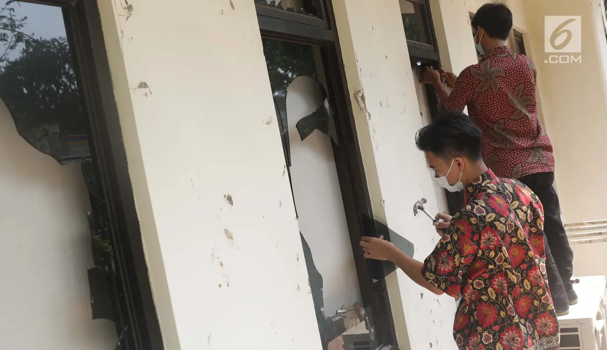 Pekerja membersihkan sisa pecahan kaca di salah satu bagian gedung Bawaslu akibat kericuhan massa aksi di perempatan Jalan MH Thamrin, Jakarta, Kamis (23/5/2019). Sebelumnya, aksi unjuk rasa yang dilakukan massa pada Rabu (23/5) berakhir ricuh. (Liputan6.com/Helmi Fithriansyah)