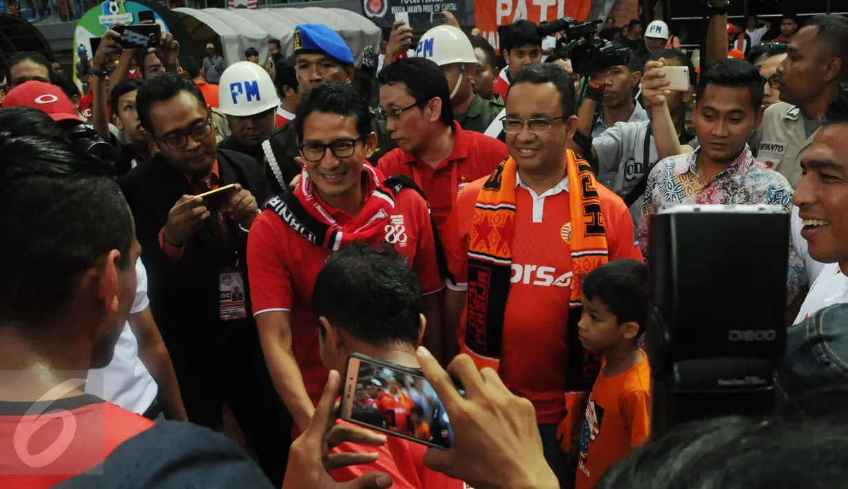 Calon Gubernur dan Wakil Gubernur DKI Jakarta Anies Baswedan bersama Sandiaga Uno dikerumuni pendukung Persija usai menonton pertandingan Persija VS Barito Putra di Stadion Patriot Bekasi, Sabtu (22/4). (Liputan6.com/Gempur M. Surya)