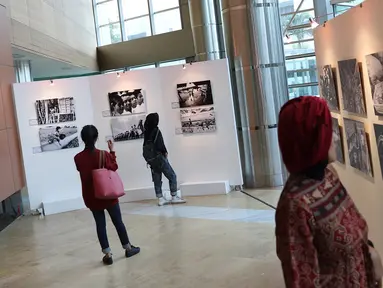 Pengunjung mengamati karya yang dipajang dalam pameran fotografi bertajuk “Semangat Anak Indonesia dalam Bingkai Hitam Putih” di Taman Ismail Marzuki (TIM), Jakarta, Selasa (20/3). (Liputan6.com/Immanuel Antonius)