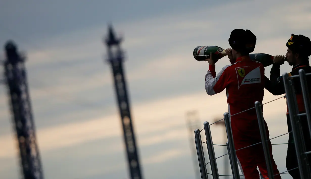 Pembalap tim Force India, Sergio Perez (kanan) dan pembalap F1 tim Ferrari, Sebastian Vettel meminum sampanye usai menjadi juara kedua dan ketiga pada ajang Grand Prix Rusia di Sochi, Minggu (11/10). (REUTERS/Grigory Dukor)