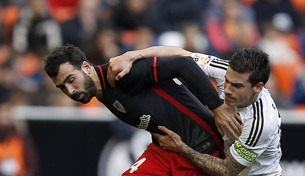 3. Gelandang Valencia, Santi Mina, berebut bola dengan bek Athletic, Mikel Balenziaga, pada laga La Liga Spanyol di Stadion Mestalla, Minggu (28/2/2016). Valencia takluk 0-3 dari Athletic. (EPA/Kai Foersterling)