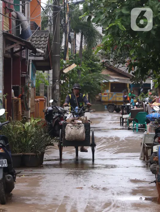 Pengumpul barang bekas berkeliling di Ciledug Indah, Tangerang, Banten, Senin (21/2./2021). Pasca banjir melanda perumahan tersebut menjadi berkah bagi para pengumpul barang rongsok karena banyak barang yang di buang pemilik rumah. (Liputan6.com/Angga Yuniar)