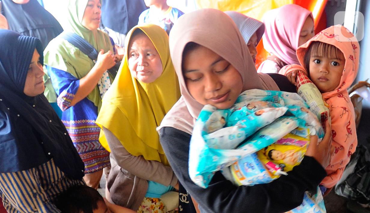 Warga antre mendapatkan pampers dan biskuit bagi anak-anak di Posko pengungsian Mangunkerta, Cianjur, Jumat (23/12/2022). Lebih dari sebulan sejak musibah gempa bumi 5,2 SR sejumlah warga masih tinggal di pengungsian dengan bantuan kebutuhan hidup dari para donatur. (merdeka.com/Arie Basuki)