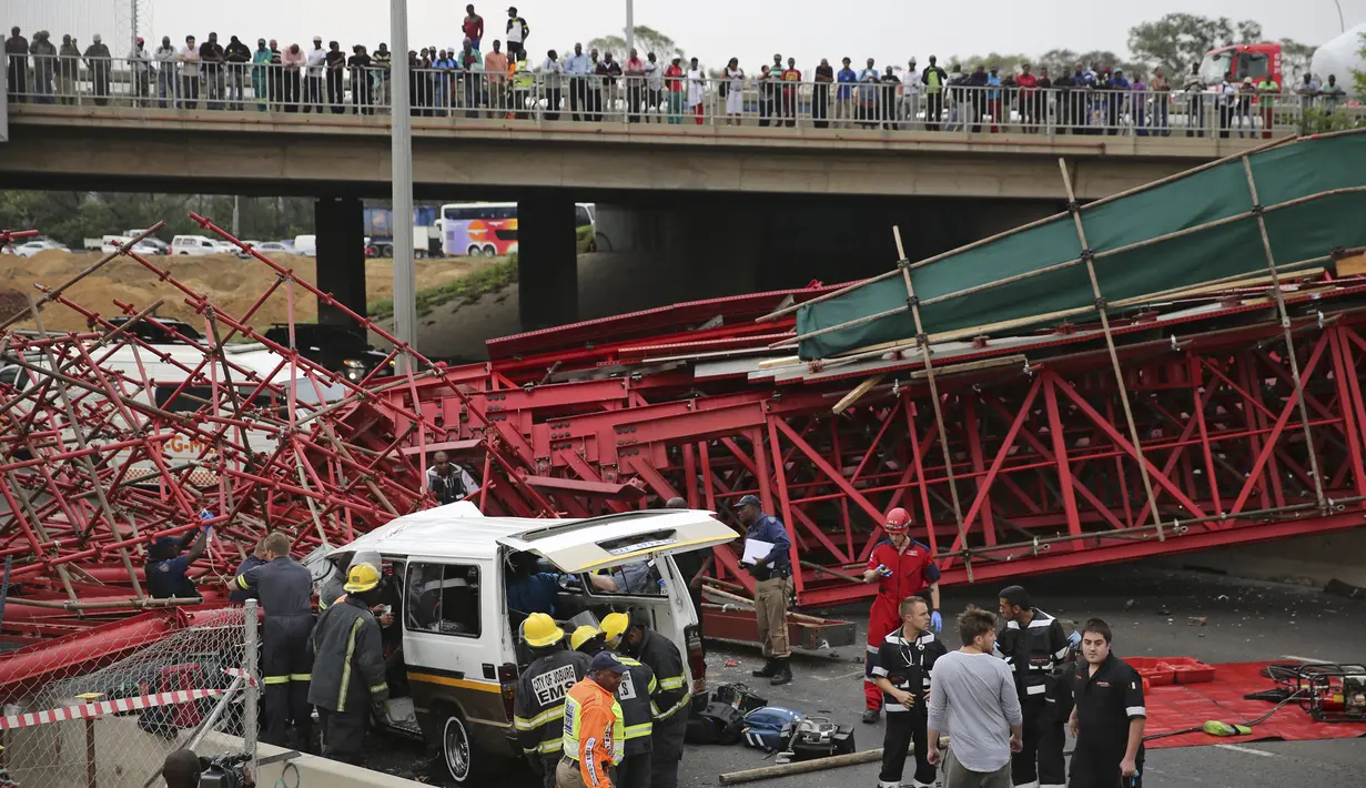 Warga mengamati paramedis yang mengevakuasi korban setelah perancah atau scaffolding sebuah jembatan yang sedang dibangun ambruk di jalan tol M1 menuju Sandton, Afrika Selatan, Rabu (14/10). Kejadian tersebut menewaskan dua orang. (REUTERS/Siphiwe Sibeko)