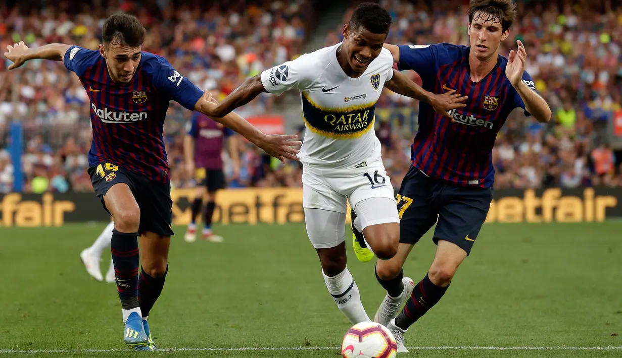 Pemain Boca Juniors, Wilmar Barrios menggiring bola dari kejaran dua pemain Barcelona selama pertandingan Piala Joan Gamper di stadion Camp Nou, Spanyol (15/8). Barcelona menang telak 3-0 atas Boca Juniors. (AP Photo/Manu Fernandez)