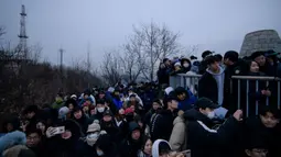 Orang-orang berkumpul di sudut pandang yang menghadap ke cakrawala kota untuk menyaksikan matahari terbit pertama tahun baru, meskipun dalam kondisi mendung, di Seoul, Korea Selatan (1/1/2020). (AFP/Ed Jones)
