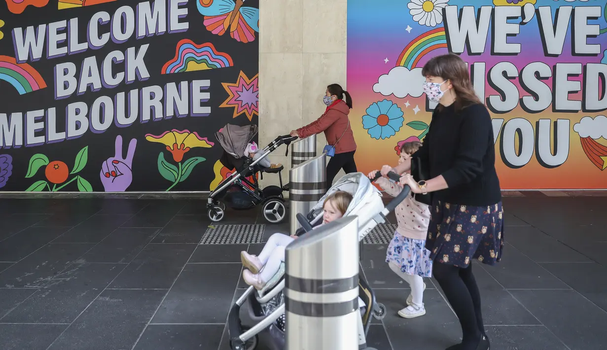 Perempuan dengan mengenakan masker mendorong kereta bayi di Melbourne, Australia, Rabu (28/10/2020). Restoran-restoran dan kafe di Melbourne diizinkan untuk dibuka lagi setelah pemberlakuan lockdown yang ketat selama lebih dari tiga bulan akibat Covid-19.  (AP Photo/Asanka Brendon Ratnayake)