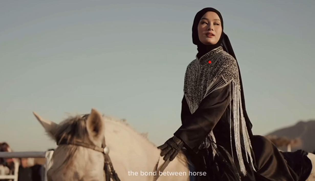 Dinda Hauw, bersama suami tercinta Rey Mbayang, terlihat menikmati "riding date" mereka di tengah keindahan gurun pasir. Penampilan Dinda Hauw yang anggun dalam balutan outfit serba hitam, dipadu cape beraksen bordir perak dan hijab hitam, sukses mencuri perhatian. (Liputan6.com/IG/@dindahw)