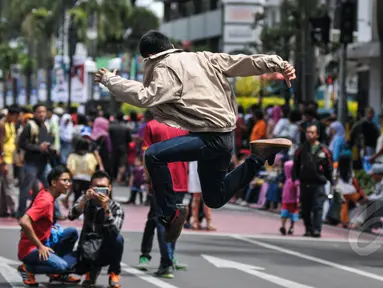 Seorang warga berfoto di Jalan Asia Afrika, Bandung yang sedang disterilkan dari kendaraan bermotor, Jumat (24/2015). Pensterilan jalan diberlakukan saat berlangsungnya puncak perayaan ke-60 Konferensi Asia Afrika di Bandung. (Liputan6.com/Faizal Fanani)