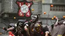 Sejumlah orang yang mengenakan helm melemparkan jeruk kepada warga sebagai bagian dari tradisi "perang jeruk" yang diselenggarakan selama Karnaval Ivrea di Turin, Italia (16/2). (AFP PHOTO/Olivier MORIN)