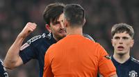 Bek Manchester United (MU), Harry Maguire, memprotes keputusan wasit Andy Madley yang memberikan penalti untuk Arsenal pada laga putaran ketiga Piala FA 2024/2025 di Emirates Stadium, Sabtu (12/1/2025). (Glyn KIRK / AFP)