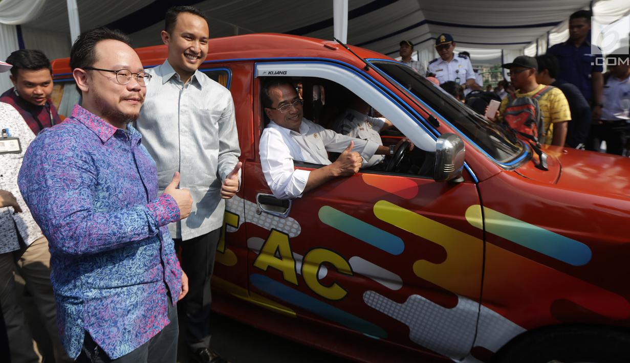 Senior VP Operational GO JEK,Arno Tse, Senior Public Policy Associate Uber, Pandu Adi Laras  dan Menteri Perhubungan Budi Karya Sumadi saat meluncurkan program Angkutan Kota ber-AC di Monas, Jakarta, Sabtu (1/7).(Liputan6.com)