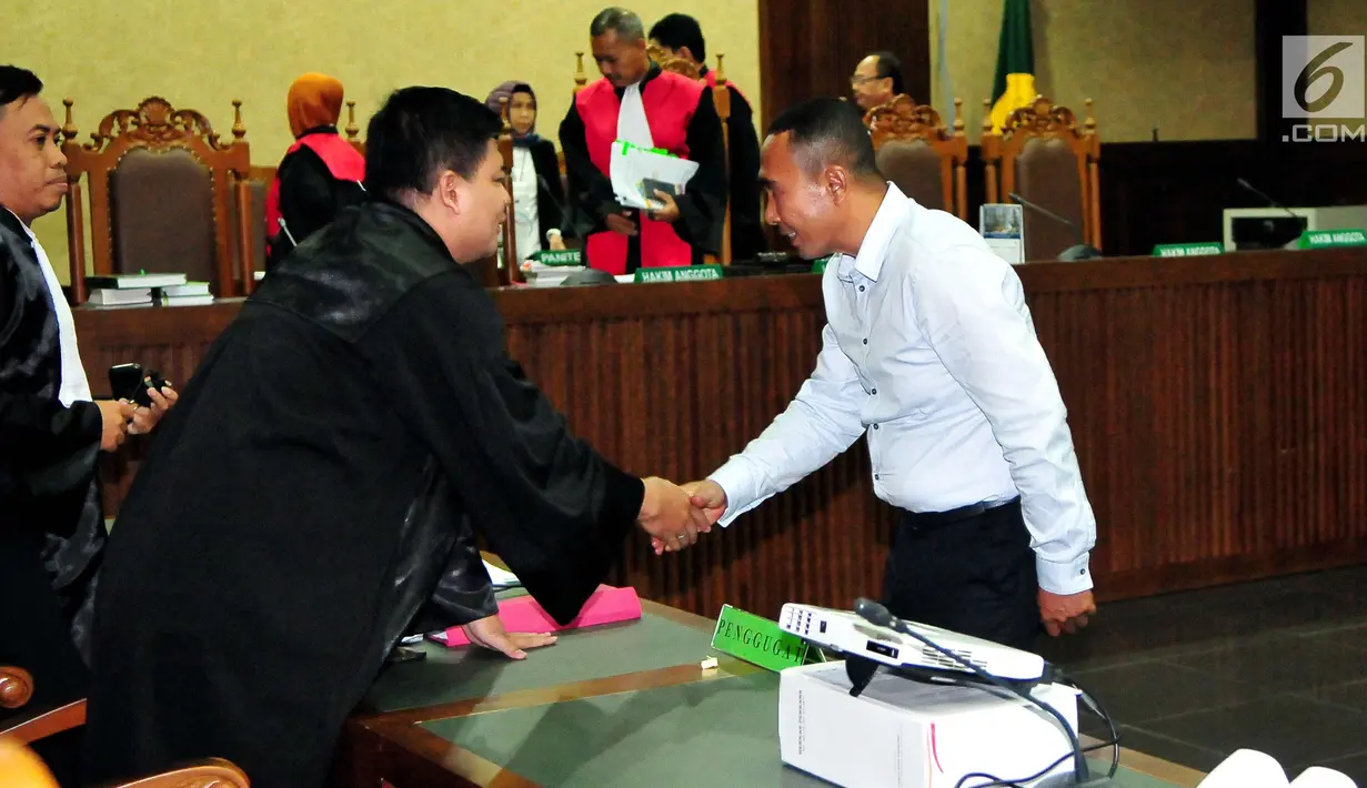 Bupati nonaktif Buton, Samsu Umar Abdul Samiun bersalaman dengan tim kuasa hukum usai menjalani sidang di Pengadilan Tipikor Jakarta, Rabu (27/9) . Samsu Umar divonis  3 tahun 9 bulan penjara oleh Majelis Hakim. (Liputan6.com/Helmi Afandi)
