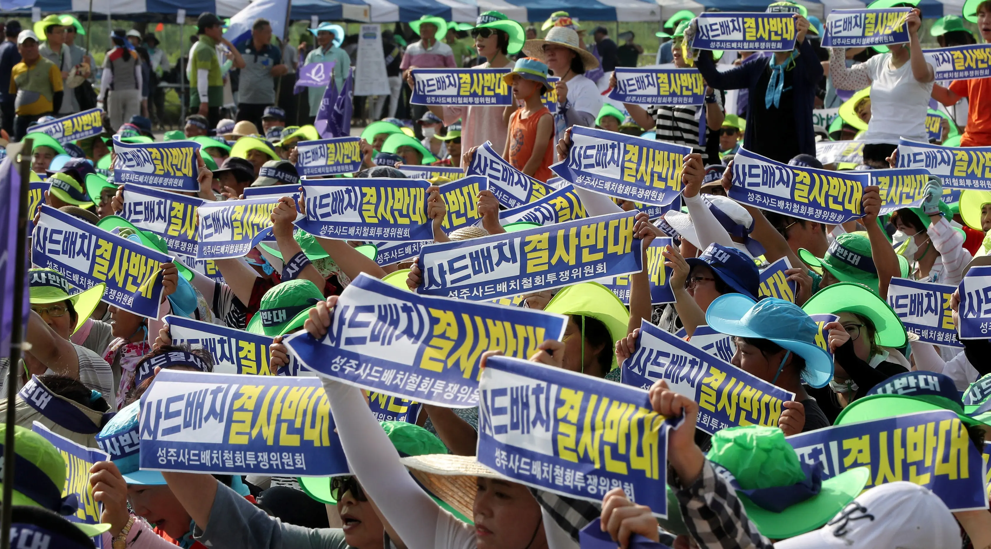 Warga membawa selembaran sambil melontarkan protes terhadap keputusan pemerintah yang menempatkan alat pertahanan anti rudal AS Terminal High Altitude Area Defence (THAAD) di Seongju, Korea Selatan, Senin (15/8).( Reuters/Kim Jun- beom)