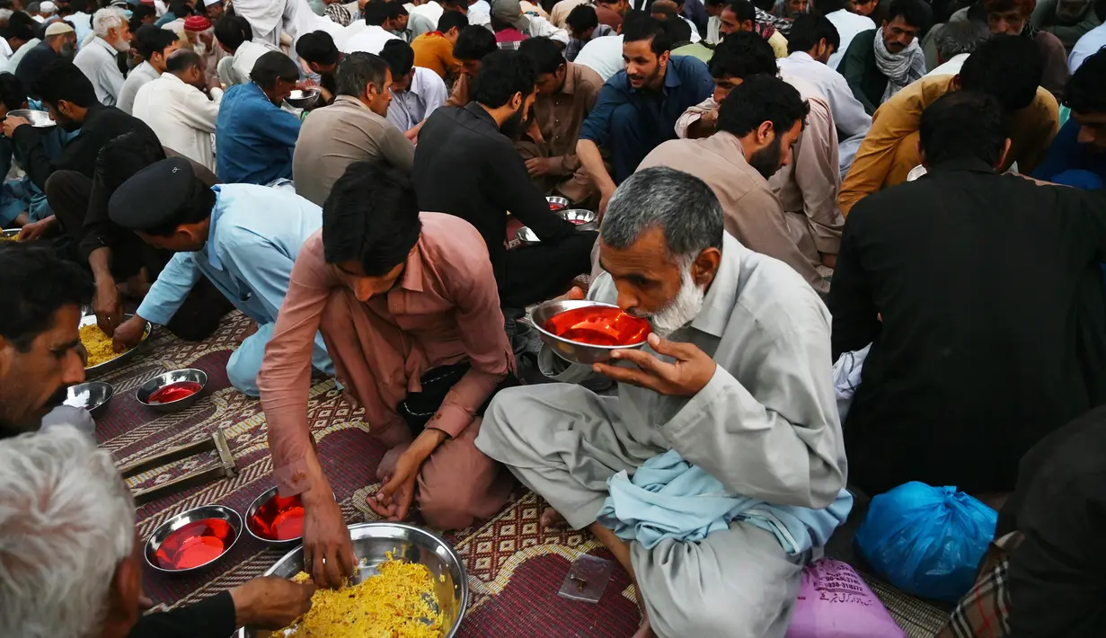 Umat Islam Pakistan berbuka puasa bersama di sepanjang jalan di Rawalpindi pada 7 Mei 2019. Ketika bulan suci Ramadan mulai di Pakistan, banyak masyarakat muslim memanfaatkan buka puasa gratis yang disponsori oleh badan-badan amal dan orang-orang kaya. (RIZWAN TABASSUM / AFP)
