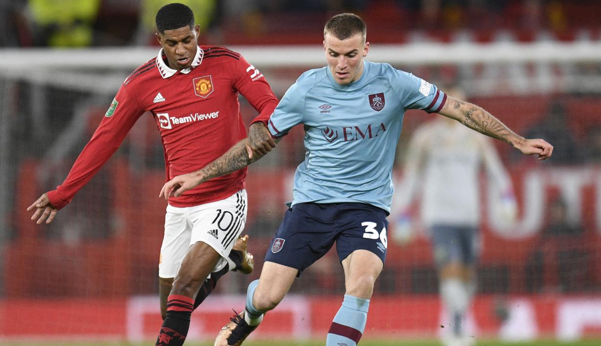 Bek Burnley, Jordan Beyer (kanan) berduel dengan striker Manchester United, Marcus Rashford pada laga putaran keempat Piala Liga Inggris 2022/2023 di Old Trafford Stadium, Manchester (21/12/2022). Jordan Beyer dipinjam Burnley dari klub Bundesliga Borussia Monchengladbach pada awal musim 2022/2023. Pemain asal Jerman ini telah tampil dalam 27 laga di Championship dengan torehan 1 gol dan 2 assist. (AFP/Oli Scarff)