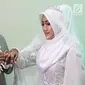 Komedian Caisar Aditya Putra memasangkan cincin ke jari Intan Sri Mardiani usai resmi menikah di kawasan Cimahpar, Bogor, Jawa Barat, Sabtu (30/6). Sama halnya dengan Caisar, Intan juga pernah menikah namun kandas. (Liputan6.com/Herman Zakharia)