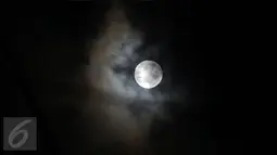 Fenomena alam Supermoon jelang tertutup awan tampak di langit Kabupaten Bogor, Jawa Barat, Senin (14/11). Fenomena ini terjadi saat bulan mencapai titik terdekat dengan bumi dalam kondisi purnama atau penuh. (Liputan6.com/Helmi Fithriansyah)