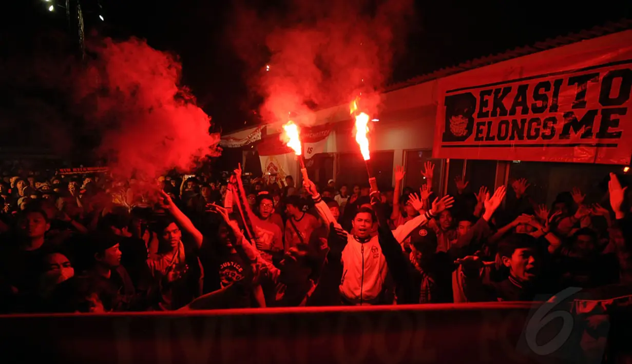 Beberapa suporter Liverpool menyalakan kembang api saat acara nonton bareng laga Manchester United vs Liverpool di Tanah Kusir, Jakarta (14/12/2014). (Liputan6.com/Helmi Fithriansyah)