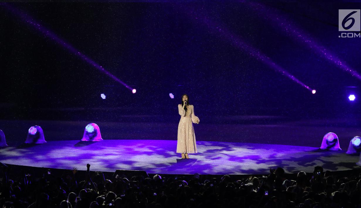 Penyanyi Isyana Sarasvati tampil dalam Upacara Penutupan Asian Games 2018 di Stadion Utama Gelora Bung Karno, Jakarta, Minggu (2/9). Vokalnya yang lembut mengalun saat mengiringi video cuplikan perjuangan para atlet. (Liputan6.com/Helmi Fithriansyah)