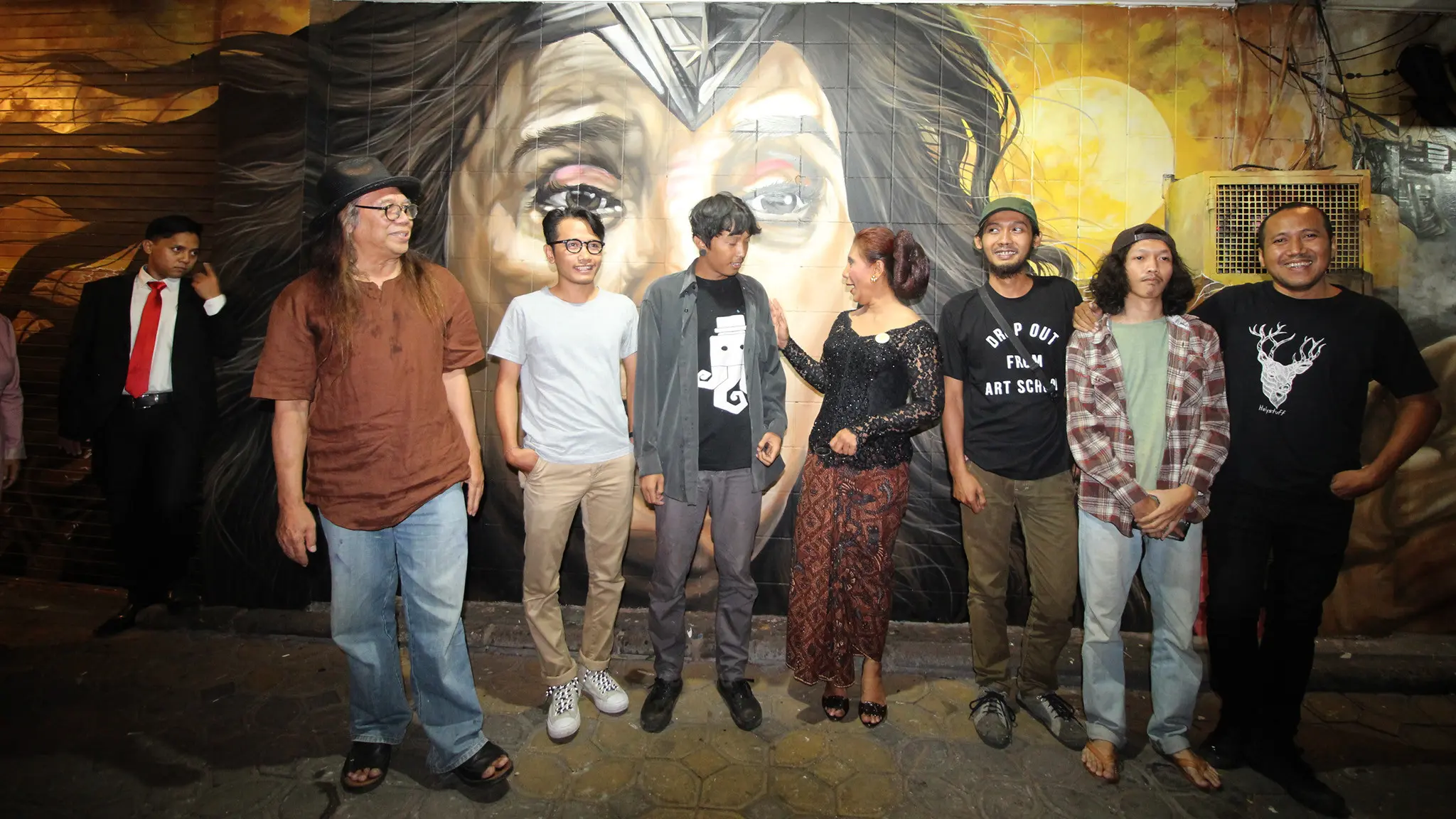 Menteri Susi Pudjiastuti bersama dengan para pelukis yang menggambar Susi Pudjiastuti bak Wonder Woman berpose di depan lukisan