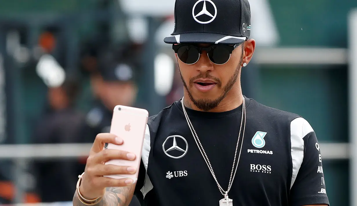 Pembalap F1 dari tim  Mercedes, Lewis Hamilton berselfie di sirkuit Internasional Shanghai untuk memulai grand prix Cina, (14/4/16). Lewis Hamilton adalah pembalap pertama Formula 1 yang berkulit gelap. (REUTERS/Aly Song)